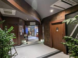 un pasillo de un edificio con una puerta y algunas plantas en The Bed and Spa - Vacation STAY 15981v, en Tokorozawa