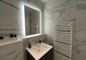 Luxury 1bedroom with Parking In Center&Large Terrace -CD3 في لوكسمبورغ: حمام أبيض مع حوض ومرآة