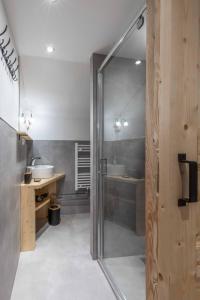 a bathroom with two sinks and a glass shower door at Ski-Bike-Apartment Bayerwald in Lohberg +24 photos