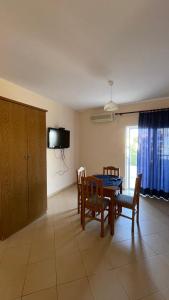 a dining room with a table and chairs and a tv at Overview Apartments Saranda in Sarandë