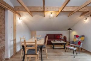 uma sala de estar com uma mesa e cadeiras e um sofá em Ski-Bike-Apartment Bayerwald em Lohberg