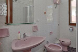 La salle de bains est pourvue d'un lavabo rose et de toilettes. dans l'établissement App.ti Scala Dei Turchi Tetide, à Porto Empedocle
