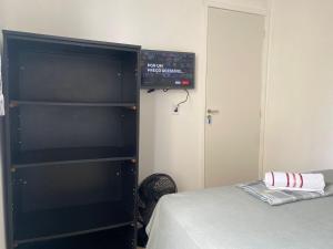 - un coin chambre avec un lit et une étagère dans l'établissement Kambô hostel, à São Paulo
