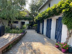 a cobblestone alley between two buildings with plants at La Parenthèse in Richebourg