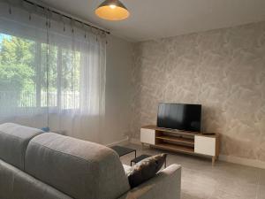 a living room with a couch and a flat screen tv at Au calme proche centre-ville, studio rénové avec équipements neufs et parking privé in Gap