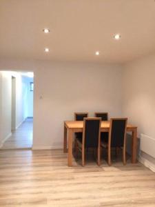 a dining room with a wooden table and chairs at Demims Apartments Oslo Airport in Eidsvoll