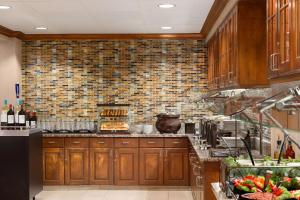 a kitchen with wooden cabinets and a brick wall at Homewood Suites by Hilton Orlando-Intl Drive/Convention Ctr in Orlando
