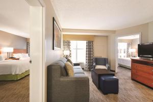 a hotel room with a couch and a bed and a tv at Homewood Suites by Hilton Orlando-Intl Drive/Convention Ctr in Orlando