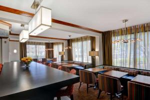 un comedor con mesas, sillas y ventanas en Hampton Inn Memphis Poplar, en Memphis