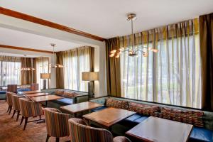 um quarto de hotel com mesas, cadeiras e janelas em Hampton Inn Memphis Poplar em Memphis
