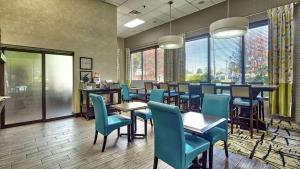 a restaurant with blue chairs and tables and windows at Hampton Inn Norfolk-Naval Base in Norfolk