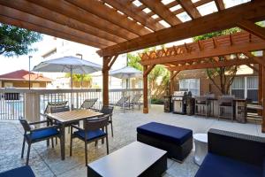 a patio with a wooden pergola and tables and chairs at Homewood Suites by Hilton San Antonio Northwest in San Antonio