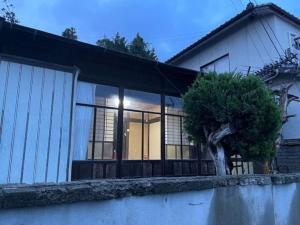 une maison avec un arbre en face dans l'établissement Otomaridokoro Shimonoseki Honmachi - Vacation STAY 15120, à Shimonoseki