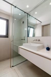 a bathroom with a sink and a glass shower at Kolonaki Square Panorama Penthouse in Athens