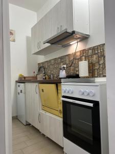 a kitchen with a black and yellow stove top oven at Adam's Apartment 1 in Kladovo
