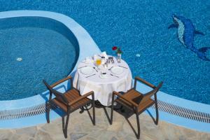a table and chairs next to a swimming pool at Maistros Village in Karterados