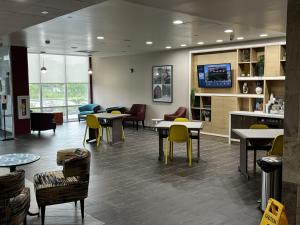 una sala d'attesa con tavoli e sedie in ospedale di Home2 Suites By Hilton Hinesville a Hinesville