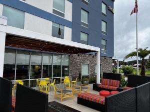 a patio with chairs and tables and a building at Home2 Suites By Hilton Hinesville in Hinesville