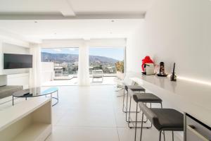 una sala de estar con un bar con taburetes en Kolonaki Square Panorama Penthouse, en Atenas