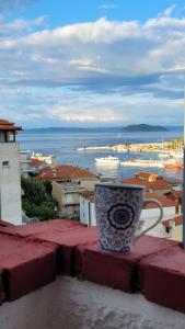 a coffee cup sitting on a ledge on a balcony at Egeon Studios in Neos Marmaras