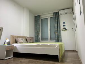 a bedroom with a large bed with a window at Adam's Apartment 1 in Kladovo