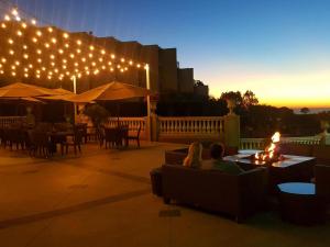 un groupe de personnes assises sur une terrasse éclairée dans l'établissement Hilton La Jolla Torrey Pines, à San Diego