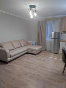 a living room with a couch and a kitchen at COZY house მყუდრო სახლი in Stepantsminda