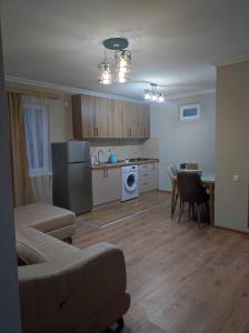a living room with a couch and a kitchen at COZY house მყუდრო სახლი in Kazbegi