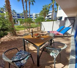 プレヤス・デ・オリフエラにあるLa Calma - one bedroom apartment by the pool in Playa Flamencaの木製テーブルと椅子付きのパティオ