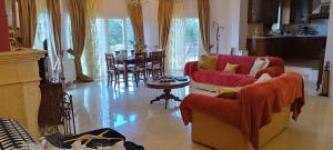 Alykes PotamouCorfu town 'PANORAMIC VIEW HOUSE'的客厅配有2把红色椅子和桌子