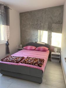 een slaapkamer met een groot bed met kussens erop bij Apartman Gabi in Subotica