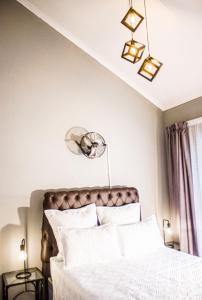 a bedroom with a bed with white sheets and lights at 19 @ Pendleberry in Bela-Bela