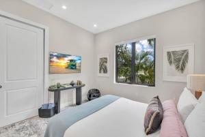 biała sypialnia z łóżkiem i oknem w obiekcie Villa in Coral Gables with Pool Jacuzzi Game Room w Miami