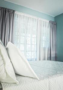Un dormitorio con una cama con almohadas blancas y una ventana en 19 @ Pendleberry en Bela-Bela