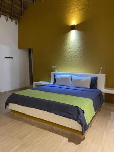 1 dormitorio con 1 cama con sábanas azules y verdes en Hotel La Palma Del Paso Real- Solo adultos, en Santa Fe de Antioquia