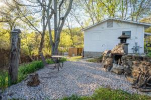 Un patio trasero con una mesa y una chimenea de piedra. en Goat Rock Cabin, en Hot Springs