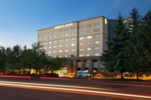 a building with a van parked in front of it at Embassy Suites By Hilton Seattle - Tacoma International Airport in Tukwila