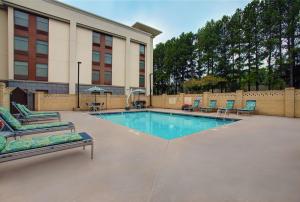a swimming pool with lounge chairs and a building at Hampton Inn Salisbury in Salisbury