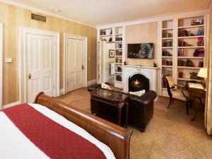 a bedroom with a bed and a fireplace and a desk at Mansion Hill Inn in Madison