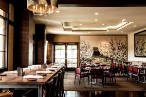 a dining room with a long table and chairs at Juniper Hotel Cupertino, Curio Collection by Hilton in Cupertino