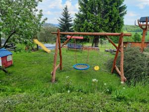 a playground with a swing set in a field at Pension Aneta in Vysoké nad Jizerou