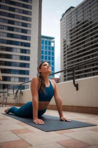 une femme faisant une pose de yoga sur un toit dans l'établissement Hilton Salt Lake City Center, à Salt Lake City