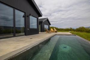 a house with a swimming pool next to a house at Svart Lodge in Akureyri