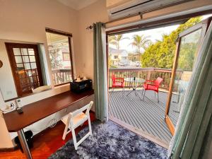 a room with a balcony with a table and chairs at The Wood House in Empangeni