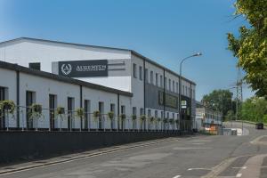 a white building with a fence next to a street at Augustus Hotel Bernkastel - Comfortable Budget Hotel in Bernkastel-Kues