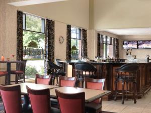 a restaurant with tables and chairs and a bar at President Abraham Lincoln - A Doubletree by Hilton Hotel in Springfield