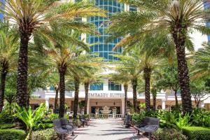 a walkway with palm trees in front of a building at Embassy Suites by Hilton Tampa Downtown Convention Center in Tampa