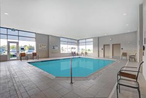 einen Pool in einem Gebäude mit Stühlen und Tischen in der Unterkunft Hampton Inn & Suites Belleville in Belleville