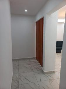 a hallway with white walls and a wooden door at Beau T2 Nouvelle Route bastos Yaoundé in Yaoundé