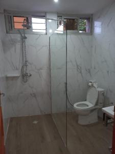 a bathroom with a toilet and a glass shower stall at Beau T2 Nouvelle Route bastos Yaoundé in Yaoundé